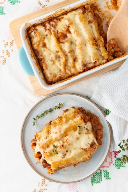 Cannelloni con ripieno di carne macinata di manzo, pomodori, al forno con salsa di pomodoro besciamella