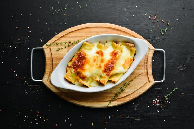 Cannelloni paste baked with meat cream sauce cheese Italian cuisine Top view Free copy space