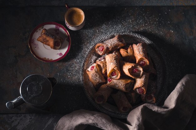 Cannoli and cup of coffee on the stone background top view horizontal