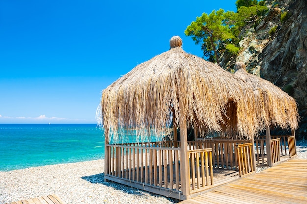 Canopy with thatched roof on the beach in Kemer, Turkey. Travel and vacation