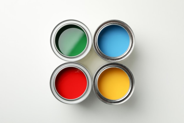 Cans of different paints on white surface