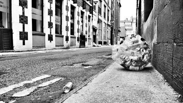 Photo cans on sidewalk amidst buildings