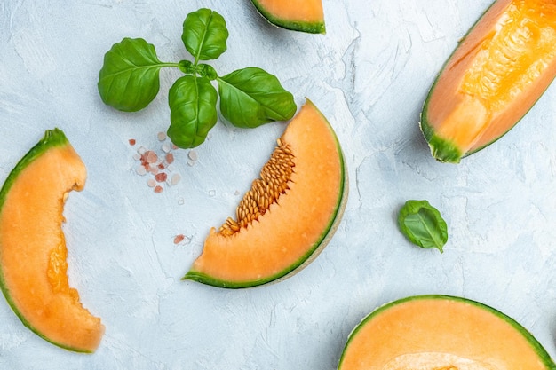Cantaloupe melon whole and slice of japanese melons orange melon with seeds on light background place for text top view