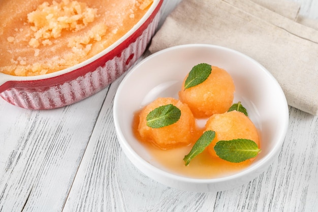 Cantaloupemuntsorbet met verse muntblaadjes in de witte kom