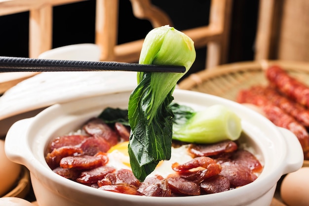 Cantonese style cooking of claypot rice with waxed meats