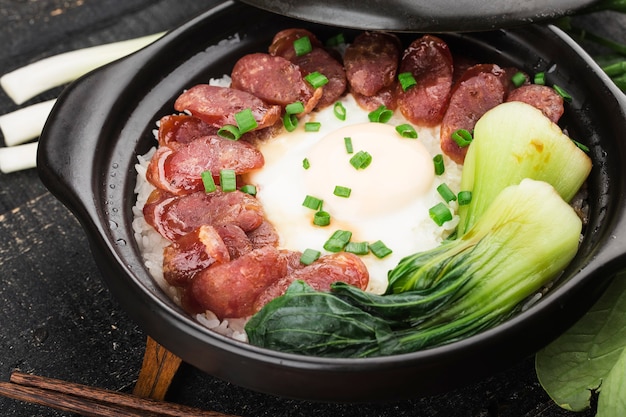 Cantonese style cooking of claypot rice with waxed meats