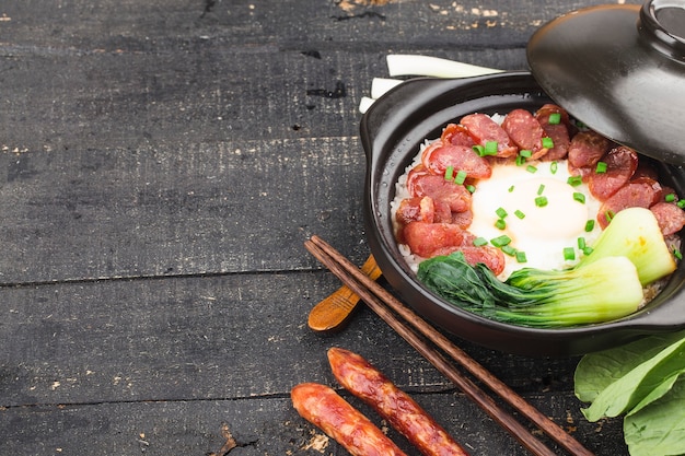 Cantonese style cooking of claypot rice with waxed meats