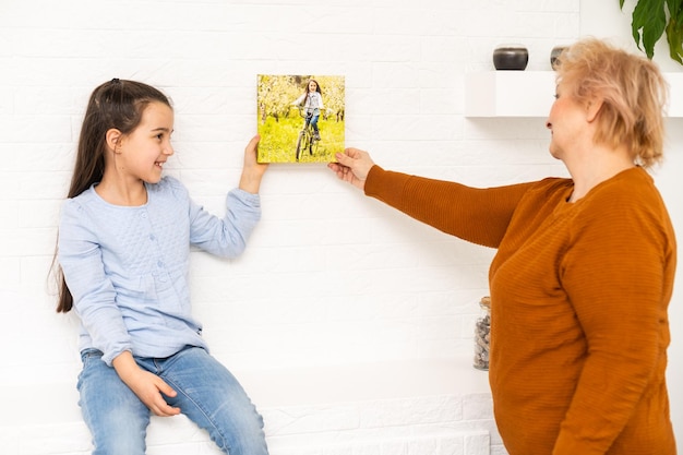 Canvas afdrukken. klein meisje en grootmoeder met foto canvas.