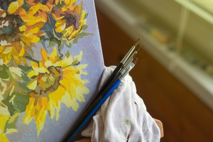 Photo canvas, paint, brushes, palette knife lying on the table.