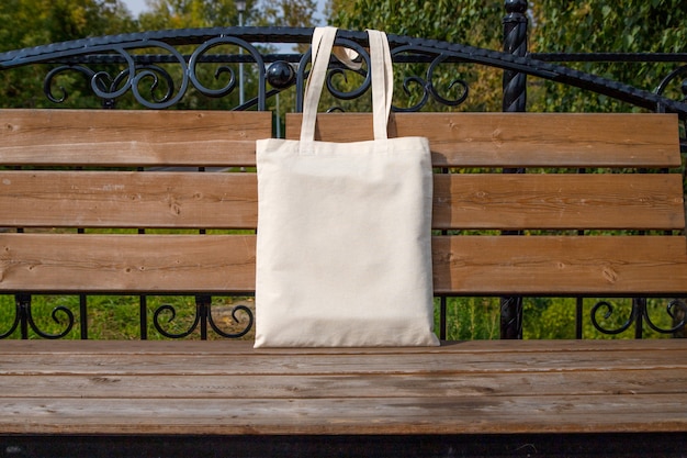 Canvas tote bag on the bench in the park mockup rustic linen\
shopper bag mock up for presentation