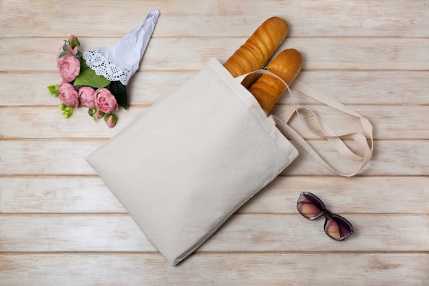 Mockup di borsa in tela con fiori rosa e baguette francese borsa shopper in lino rustico