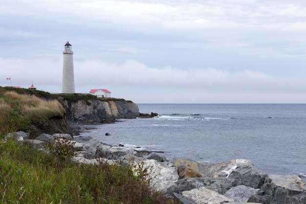 Photo the cap-des-rosiers lighthouse in gaspe quebec seen during a grey afternoon