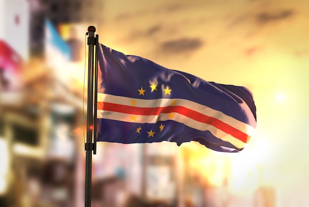 Cape Verde Flag Against City Blurred Background At Sunrise Backlight