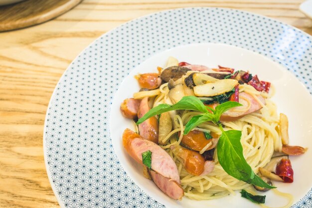 Capellini with basil and mushrooms served in plate on table