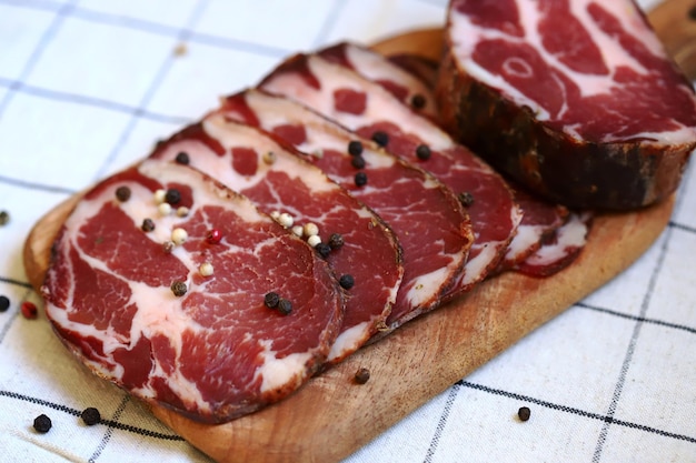 Ломтики итальянской ветчины Capocollo на доске