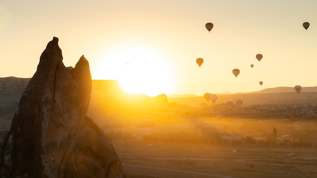 Cappadocia sunrise landscape with hot air balloons taking off at sunrise