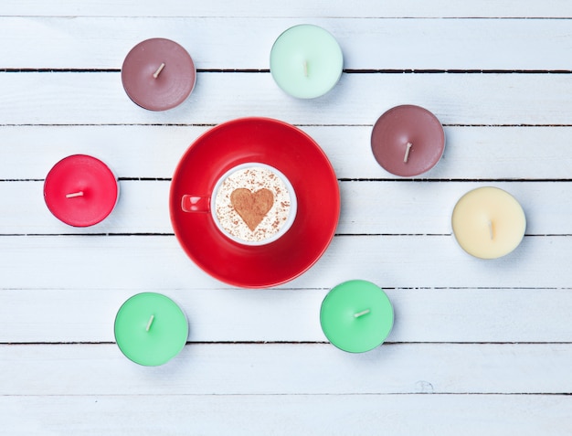 Cappuccino and candles on white background