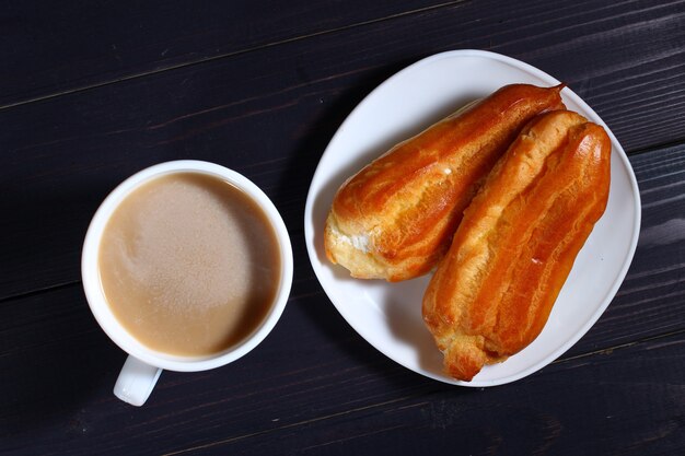 Cappuccino and choux pastry on a dark