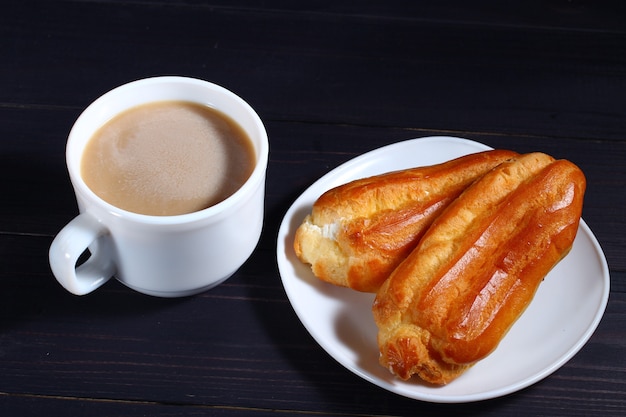 Cappuccino and choux pastry on a dark