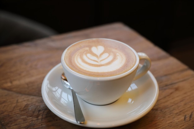 木の背景にカプチーノコーヒーカップ