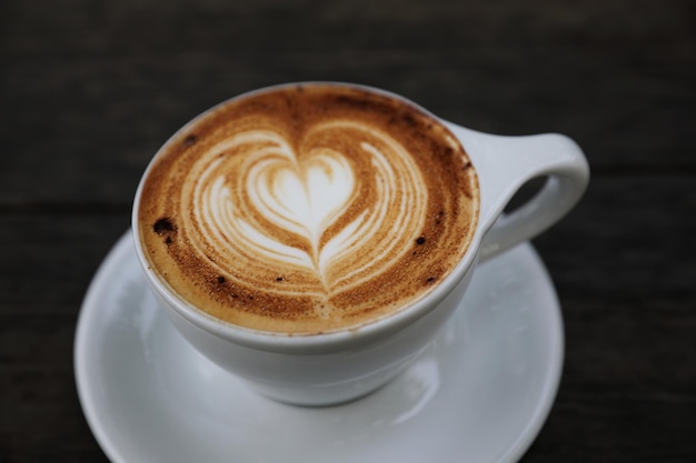 木の背景にカプチーノコーヒーカップ