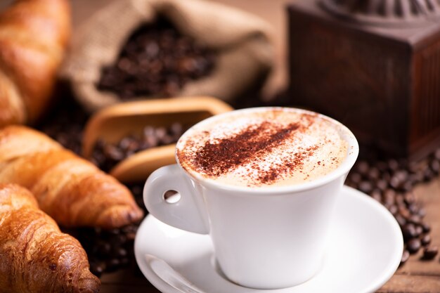 Кофе капучино над темными жареными кофейными зернами крупным планом