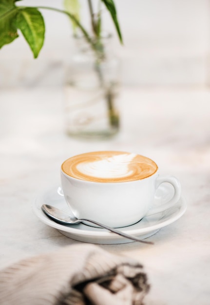 흰색 컵과 숟가락에 카푸치노 커피 음료