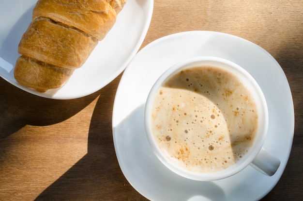 Foto cappuccino o caffè latte e croissant.