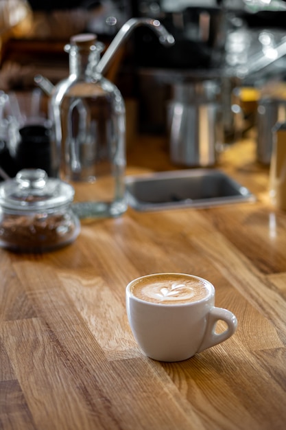 Кофе капучино с рисунком сердца на винтажном кафе.