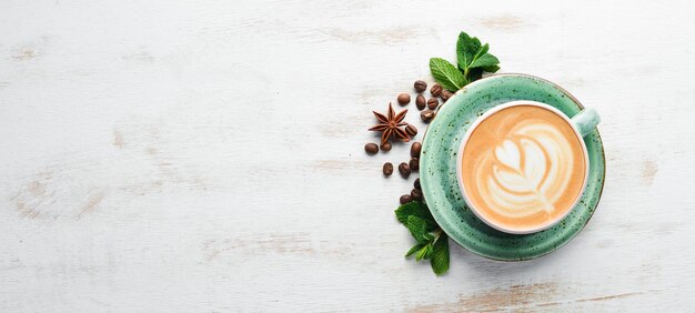Cappuccino caffè con latte su fondo di legno bianco vista dall'alto spazio per la copia gratuito