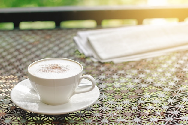 Cappuccino coffee with newspaper on vintage table 