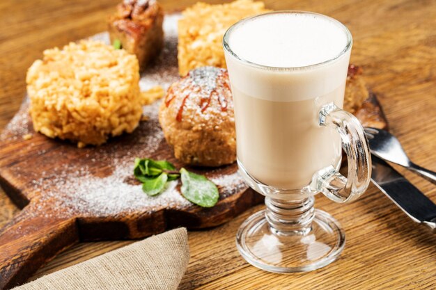 Tazza da cappuccino con latte su fondo in legno bella tazza in ceramica verde schiuma