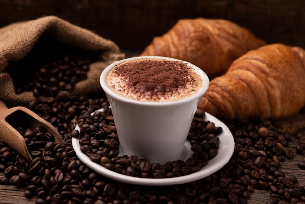 Cappuccino en croissant met koffiebonen close-up