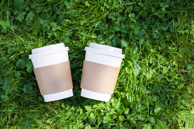 Cappuccino in een papieren beker om op een groene achtergrond te gaan