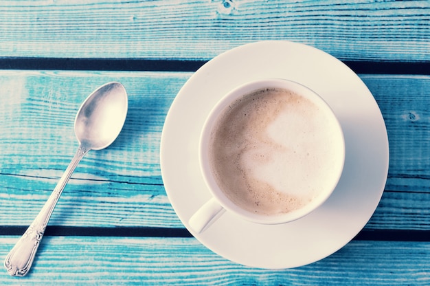 cappuccino in een witte mok op blauwe tafel