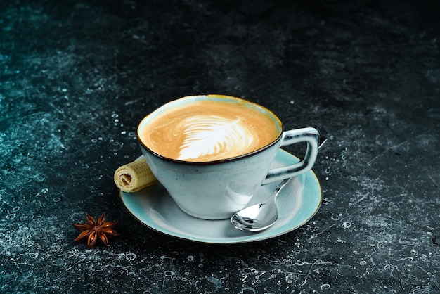 Cappuccino-koffie met melk in een kopje op een zwarte stenen achtergrond menubalk