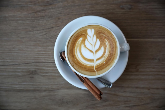 커피숍의 나무 탁자에 있는 우유로 만든 카푸치노 또는 라떼 아트 커피