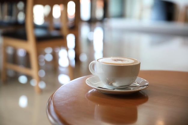 Cappuccino o latte art caffè a base di latte sul tavolo di legno nella caffetteria