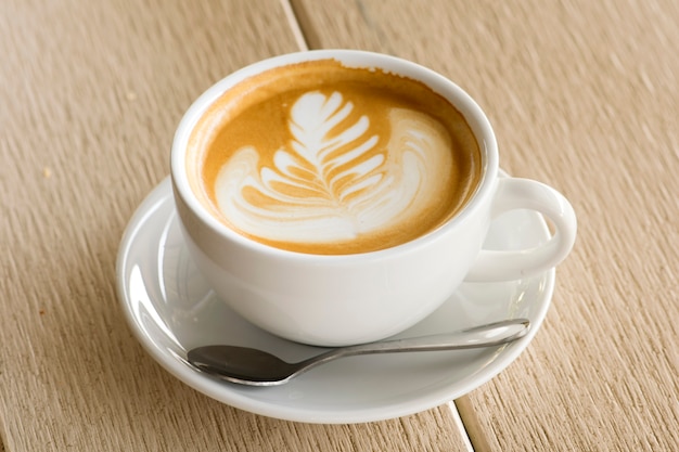 Cappuccino or latte coffee on wood background