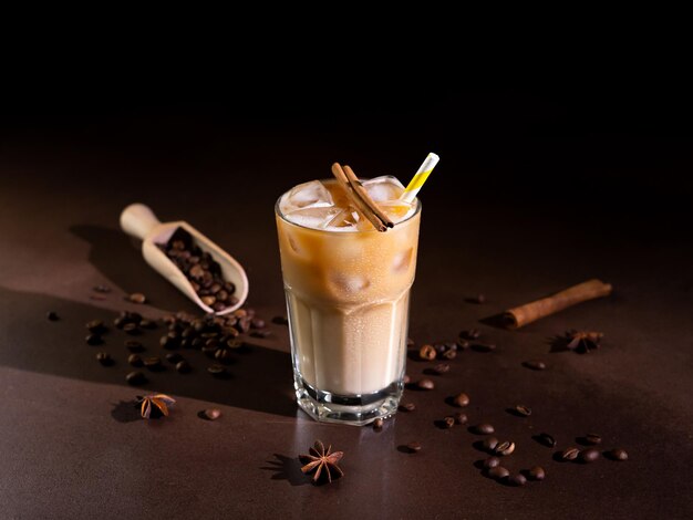 Cappuccino met ijsblokjes in een groot glas tegen een zwarte achtergrond Ijskoffie met melk