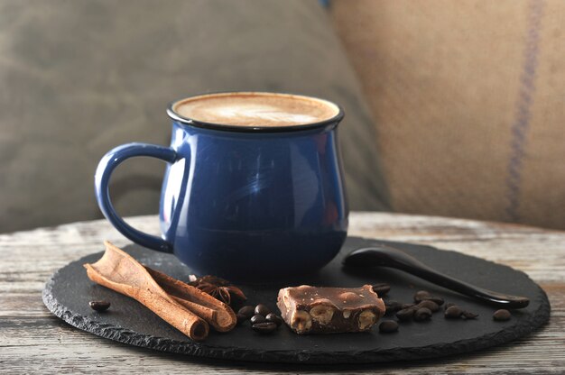 Cappuccino in a mug with milk foam and cinnamon and chocolate