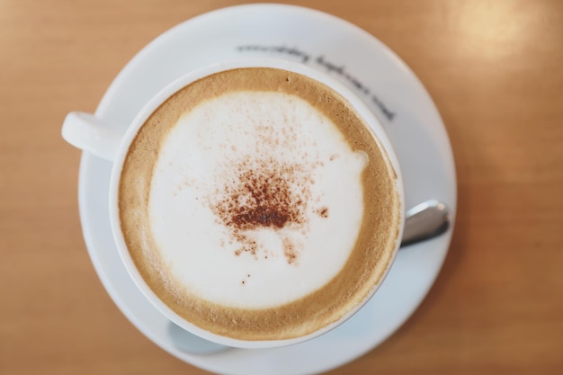 Cappuccino of Latte art koffie gemaakt van melk op de houten tafel in de coffeeshop met bovenaanzicht