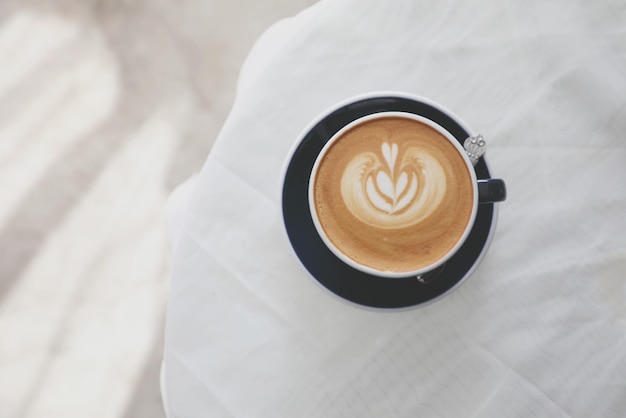 Cappuccino of Latte art koffie gemaakt van melk op de houten tafel in de coffeeshop