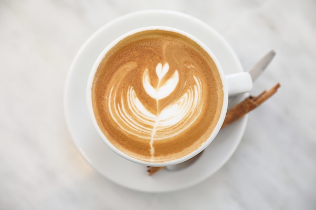 Cappuccino of Latte-kunstkoffie gemaakt van melk op de witte tafel in de coffeeshop