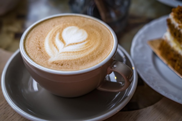 カプチーノとカフェの皿にケーキのスライス