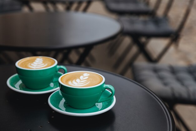 Cappuccino with lush milk foam in beautiful green colored cups