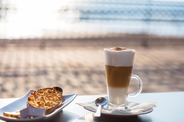 Cappuccino with toast in front of the sea
