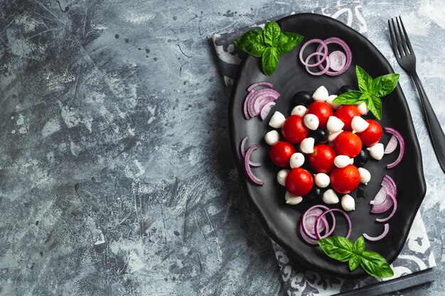 Foto caprese met kersen tomaten mini mozzarella verse basilicumbladeren traditionele italiaanse antipasto