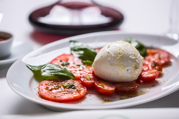 Caprese salad from mozzarella tomatoes basil olive oil an spices.