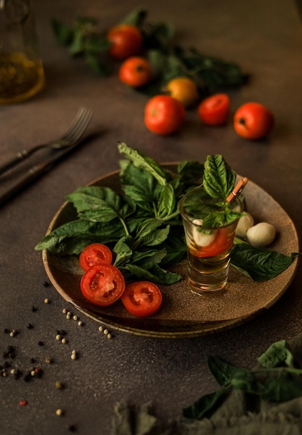 Caprese salad in a Glass for Serving in a Ceramic Plate and the Ingredients for It. Italian cuisine